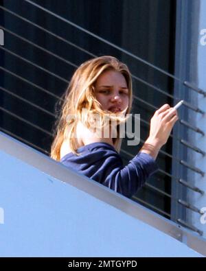 Rosie Huntington-Whiteley chats with pals and smokes a cigarette outside  her hotel in South Beach. The model is in town with her beau, Jason  Statham, to celebrate the new years at a