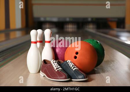 Shoes, pins and balls on bowling lane in club Stock Photo