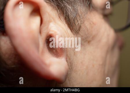 Caucasian old man ear with a growing hair in the ear Stock Photo