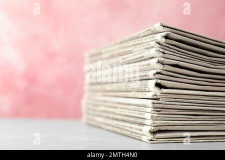 Stack of newspapers on pink background, closeup. Journalist's work Stock Photo