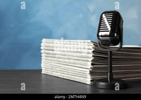 Newspapers and vintage microphone on table. Journalist's work Stock Photo
