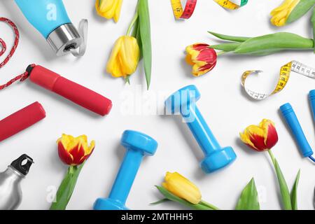 Composition with spring flowers and sports items on white background, top view Stock Photo