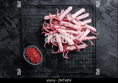 Raw Duck Tongue ready for cooking. Black background. Top view. Stock Photo