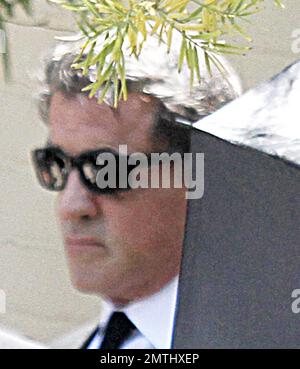 Sylvester Stallone arrives at his son Sage Stallone's funeral. Wearing a black suit and shades to hide his eyes, the actor made his way into the St. Martin of Tours Catholic Church. Sage was found dead at his LA home on the 13th July, the cause of death is yet to be confirmed. Brentwood, CA, 21st of July, 2012. Stock Photo