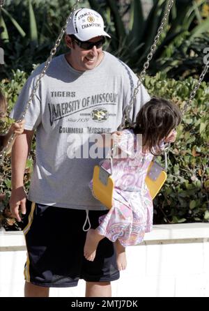 Actor Adam Sandler and family spend the Labor Day holiday together at Malibu Country Mart. During the day out, Sandler took time to push his youngest daughter Sunny on the swing set. Malibu, CA. 5th September 2011. Stock Photo