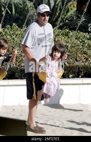 Actor Adam Sandler and family spend the Labor Day holiday together at Malibu Country Mart. During the day out, Sandler took time to push his youngest daughter Sunny on the swing set. Malibu, CA. 5th September 2011. Stock Photo
