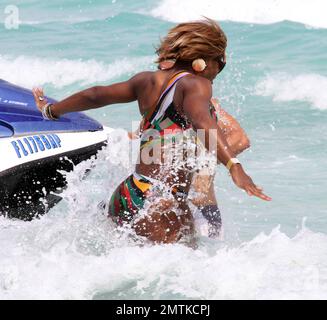 Serena Williams spends a relaxing afternoon on the beach soaking up the sun wearing a brightly colored cutaway bathing suit. She took a ride on a jetski, sipped a cocktail and chatted with pals. She also splashed around in the ocean which was a bit chilly at first and she screamed as the cold waves hit her. Serena is currently on a tennis break due to injury. Miami, FL. 3/25/10.      . Stock Photo