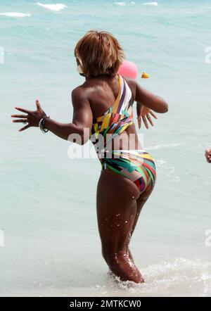 Serena Williams spends a relaxing afternoon on the beach soaking up the sun wearing a brightly colored cutaway bathing suit. She took a ride on a jetski, sipped a cocktail and chatted with pals. She also splashed around in the ocean which was a bit chilly at first and she screamed as the cold waves hit her. Serena is currently on a tennis break due to injury. Miami, FL. 3/25/10.    . Stock Photo
