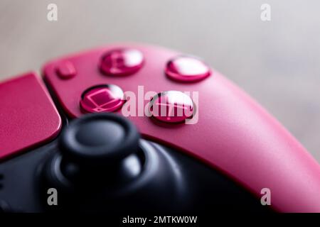 Brecht, Belgium - 26 januari 2023: A close up portrait of the classic buttons of a sony playstation 5 cosmic red wireless controller. The triangle, sq Stock Photo