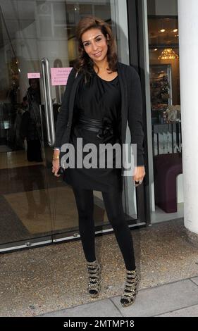 Wearing a black dress paired with some animal print heels, 'Coronation Street' star Shobna Gulati poses for photos after shopping at Lipsy in London, UK. 11/24/10. Stock Photo