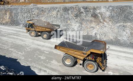 Huge dumpers working at a limestone quarry. Stock Photo