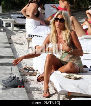 EXCLUSIVE!! Swedish model Victoria Silvstedt stuns in a pastel dress that shows off her famous curves during an afternoon by the pool. The 38 year old bombshell blonde sipped wine as she chatted with friends, re-applied her lip gloss, then sat in the sun at the end of the day soaking up the last few rays before leaving her hotel. Miami Beach, FL. 13th October 2012. Stock Photo