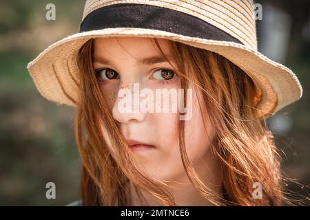 portrait of a serious cute girl with red hair and freckles in a hat Stock Photo