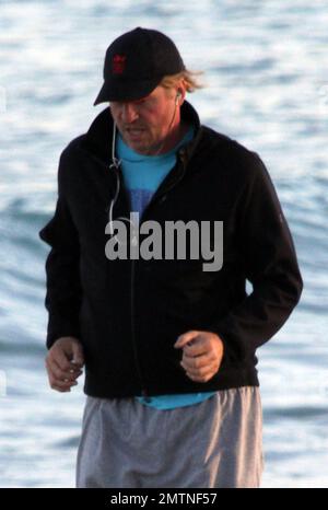 EXCLUSIVE!! Val Kilmer jogs off his Thanksgiving dinner with a sunset run on the beach. What a difference a few months makes! The actor who turns 52 on new years eve, was looking slimmer than when he was spotted on the set of his film 'Seven Below' in Cincinatti last August and at one point appeared to be loosing his shorts. Kilmer has several upcoming filming projects including 'The Hard Ride,' a western movie about a legendary gunfighter. Miami Beach, FL. 29th November 2011. Stock Photo