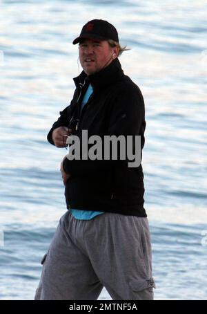 EXCLUSIVE!! Val Kilmer jogs off his Thanksgiving dinner with a sunset run on the beach. What a difference a few months makes! The actor who turns 52 on new years eve, was looking slimmer than when he was spotted on the set of his film 'Seven Below' in Cincinatti last August and at one point appeared to be loosing his shorts. Kilmer has several upcoming filming projects including 'The Hard Ride,' a western movie about a legendary gunfighter. Miami Beach, FL. 29th November 2011. Stock Photo