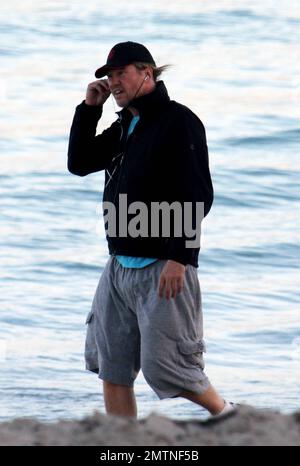 EXCLUSIVE!! Val Kilmer jogs off his Thanksgiving dinner with a sunset run on the beach. What a difference a few months makes! The actor who turns 52 on new years eve, was looking slimmer than when he was spotted on the set of his film 'Seven Below' in Cincinatti last August and at one point appeared to be loosing his shorts. Kilmer has several upcoming filming projects including 'The Hard Ride,' a western movie about a legendary gunfighter. Miami Beach, FL. 29th November 2011. Stock Photo