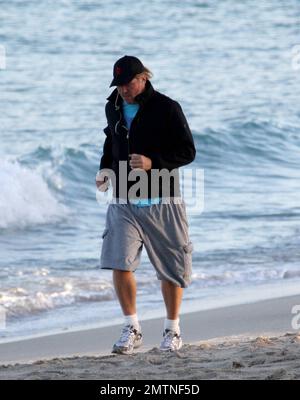 EXCLUSIVE!! Val Kilmer jogs off his Thanksgiving dinner with a sunset run on the beach. What a difference a few months makes! The actor who turns 52 on new years eve, was looking slimmer than when he was spotted on the set of his film 'Seven Below' in Cincinatti last August and at one point appeared to be loosing his shorts. Kilmer has several upcoming filming projects including 'The Hard Ride,' a western movie about a legendary gunfighter. Miami Beach, FL. 29th November 2011. Stock Photo