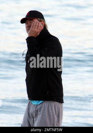 EXCLUSIVE!! Val Kilmer jogs off his Thanksgiving dinner with a sunset run on the beach. What a difference a few months makes! The actor who turns 52 on new years eve, was looking slimmer than when he was spotted on the set of his film 'Seven Below' in Cincinatti last August and at one point appeared to be loosing his shorts. Kilmer has several upcoming filming projects including 'The Hard Ride,' a western movie about a legendary gunfighter. Miami Beach, FL. 29th November 2011. Stock Photo