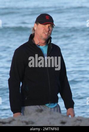 EXCLUSIVE!! Val Kilmer jogs off his Thanksgiving dinner with a sunset run on the beach. What a difference a few months makes! The actor who turns 52 on new years eve, was looking slimmer than when he was spotted on the set of his film 'Seven Below' in Cincinatti last August and at one point appeared to be loosing his shorts. Kilmer has several upcoming filming projects including 'The Hard Ride,' a western movie about a legendary gunfighter. Miami Beach, FL. 29th November 2011. Stock Photo