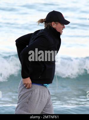 EXCLUSIVE!! Val Kilmer jogs off his Thanksgiving dinner with a sunset run on the beach. What a difference a few months makes! The actor who turns 52 on new years eve, was looking slimmer than when he was spotted on the set of his film 'Seven Below' in Cincinatti last August and at one point appeared to be loosing his shorts. Kilmer has several upcoming filming projects including 'The Hard Ride,' a western movie about a legendary gunfighter. Miami Beach, FL. 29th November 2011. Stock Photo