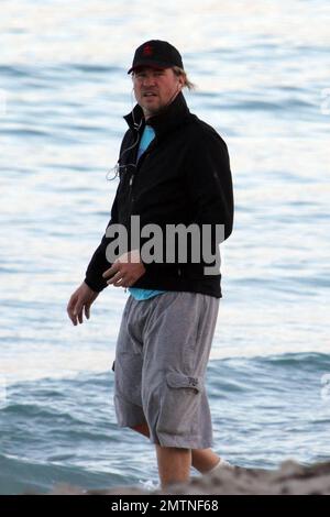 EXCLUSIVE!! Val Kilmer jogs off his Thanksgiving dinner with a sunset run on the beach. What a difference a few months makes! The actor who turns 52 on new years eve, was looking slimmer than when he was spotted on the set of his film 'Seven Below' in Cincinatti last August and at one point appeared to be loosing his shorts. Kilmer has several upcoming filming projects including 'The Hard Ride,' a western movie about a legendary gunfighter. Miami Beach, FL. 29th November 2011. Stock Photo