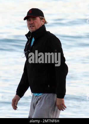 EXCLUSIVE!! Val Kilmer jogs off his Thanksgiving dinner with a sunset run on the beach. What a difference a few months makes! The actor who turns 52 on new years eve, was looking slimmer than when he was spotted on the set of his film 'Seven Below' in Cincinatti last August and at one point appeared to be loosing his shorts. Kilmer has several upcoming filming projects including 'The Hard Ride,' a western movie about a legendary gunfighter. Miami Beach, FL. 29th November 2011. Stock Photo