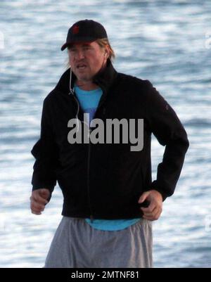 EXCLUSIVE!! Val Kilmer jogs off his Thanksgiving dinner with a sunset run on the beach. What a difference a few months makes! The actor who turns 52 on new years eve, was looking slimmer than when he was spotted on the set of his film 'Seven Below' in Cincinatti last August and at one point appeared to be loosing his shorts. Kilmer has several upcoming filming projects including 'The Hard Ride,' a western movie about a legendary gunfighter. Miami Beach, FL. 29th November 2011. Stock Photo