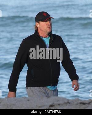 EXCLUSIVE!! Val Kilmer jogs off his Thanksgiving dinner with a sunset run on the beach. What a difference a few months makes! The actor who turns 52 on new years eve, was looking slimmer than when he was spotted on the set of his film 'Seven Below' in Cincinatti last August and at one point appeared to be loosing his shorts. Kilmer has several upcoming filming projects including 'The Hard Ride,' a western movie about a legendary gunfighter. Miami Beach, FL. 29th November 2011. Stock Photo