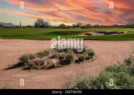 Dramatic sunset with clouds in the desert over a golf course fairway Stock Photo