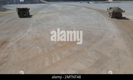 Huge dumpers working at a limestone quarry. Stock Photo