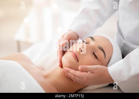Closeup Shot Of Young Indian Female Having Face Massage In Spa Salon Stock Photo