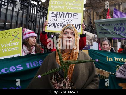 Lisamarie Johnson (centre), holding a traditional St. Brigid's Cross made from rushes, attends a St Brigid's Day rally outside Leinster House, Dublin, calling on the Government to take action in addressing violence against women in Ireland. The rally was held to coincide with St Brigid’s Day, with speakers asking that women be protected in the spirit of the Celtic goddess and Christian saint Brigid, who is associated with healing. Picture date: Wednesday February 1, 2023. Stock Photo