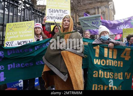 Lisamarie Johnson (centre), holding a traditional St. Brigid's Cross made from rushes, attends a St Brigid's Day rally outside Leinster House, Dublin, calling on the Government to take action in addressing violence against women in Ireland. The rally was held to coincide with St Brigid’s Day, with speakers asking that women be protected in the spirit of the Celtic goddess and Christian saint Brigid, who is associated with healing. Picture date: Wednesday February 1, 2023. Stock Photo