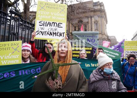 Lisamarie Johnson (centre left), holding a traditional St. Brigid's Cross made from rushes, attends a St Brigid's Day rally outside Leinster House, Dublin, calling on the Government to take action in addressing violence against women in Ireland. The rally was held to coincide with St Brigid’s Day, with speakers asking that women be protected in the spirit of the Celtic goddess and Christian saint Brigid, who is associated with healing. Picture date: Wednesday February 1, 2023. Stock Photo