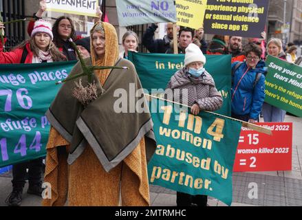 Lisamarie Johnson (centre left), holding a traditional St. Brigid's Cross made from rushes, attends a St Brigid's Day rally outside Leinster House, Dublin, calling on the Government to take action in addressing violence against women in Ireland. The rally was held to coincide with St Brigid’s Day, with speakers asking that women be protected in the spirit of the Celtic goddess and Christian saint Brigid, who is associated with healing. Picture date: Wednesday February 1, 2023. Stock Photo