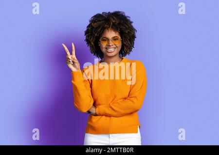 Cool stylish young black woman posing on purple Stock Photo