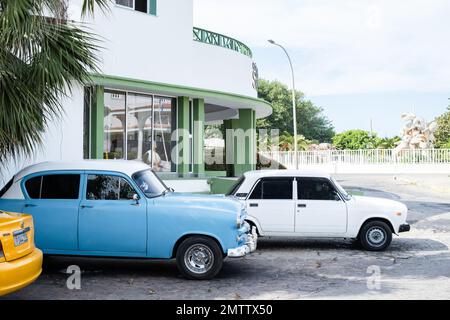 Classic cars parked outside an art deco style building in Varadero, Cuba Stock Photo