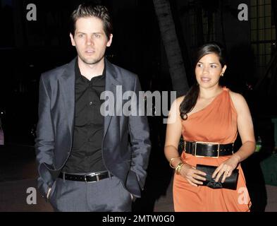 Clad in a flattering orange cocktail dress and wide belt, actress America Ferrera and her fiance director Ryan Piers Williams arrive at the Colony Theater on Lincoln Road for a red carpet screening of 'The Dry Land' directed by Ryan Piers Williams, starring America Ferrera and Wilmer Valderrama.  At the theatre the trio of stars appeared to be having a great time as they posed on the red carpet and chatted with each other and some friends. An after party followed at LIV nightclub at Fontainebleau Miami Beach, featuring DJ Rony Seikaly. Miami Beach, FL. 08/21/10. Stock Photo