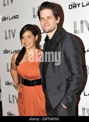 Clad in a flattering orange cocktail dress and wide belt, actress America Ferrera and her fiance director Ryan Piers Williams arrive at the Colony Theater on Lincoln Road for a red carpet screening of 'The Dry Land' directed by Ryan Piers Williams, starring America Ferrera and Wilmer Valderrama.  At the theatre the trio of stars appeared to be having a great time as they posed on the red carpet and chatted with each other and some friends. An after party followed at LIV nightclub at Fontainebleau Miami Beach, featuring DJ Rony Seikaly. Miami Beach, FL. 08/21/10. Stock Photo