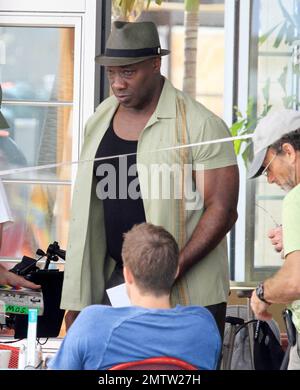 Michael Clarke Duncan film scenes on location for the TV series 'The Finder'.  While on set Michael Clarke Duncan, who got his make up touched up by a makeup artist, Geoff Stults and Saffron Burrows had a good laugh in between takes.  Saffron Burrows, who took direction and appeared to be playing the part of a waitress, looked great in aviator sunglasses, a tight brown top and flare jeans. Miami, FL. 02/24/11. Stock Photo