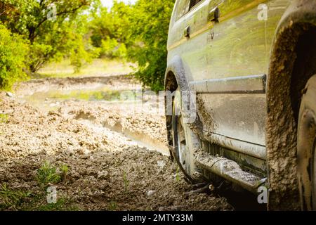 Close up view 4wd drive wheel spins through mud isolated stuck on adventure tour outdoors Stock Photo