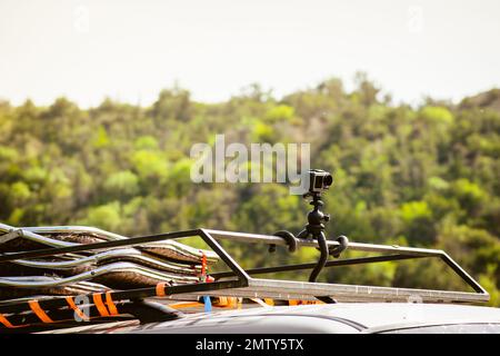 Action sports camera on rooftop attached with gorilla tripod ready documenting adventure on safari tour outdoors. Shooting and filming travels. Hyperl Stock Photo