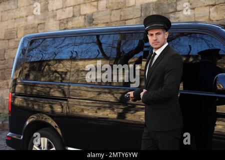 Driver opening door of luxury car. Chauffeur service Stock Photo