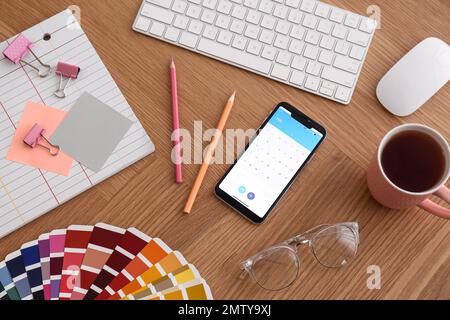 Smartphone on wooden table, above view. Designer's workplace Stock Photo