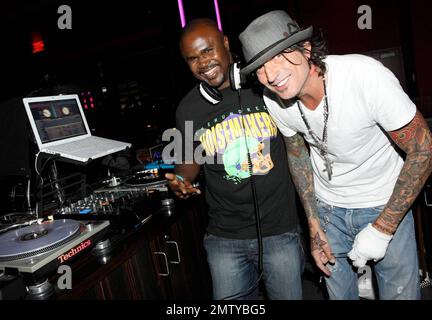 EXCLUSIVE!! Rocker Tommy Lee poses with DJ Kirk at Aura nightclub at Atlantis Paradise Island. Lee made several song requests and was very happy to find the songs he likes. Paradise Island, Bahamas. 8/26/09. Stock Photo