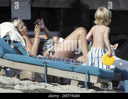 EXCLUSIVE!! Pregnant actress and author Tori Spelling wears a patterned swim suit as she relaxes on the beach with her dogs and son Liam during the Fourth of July holiday in Malibu, CA. 7/4/11.   . Stock Photo