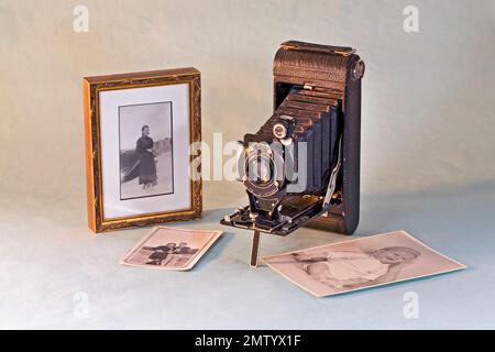 A vintage, 1926, 21/4 x 21/4 bellows camera with photographs that could have been made by a similar camera. Models are deceased. Photographer's Parent Stock Photo