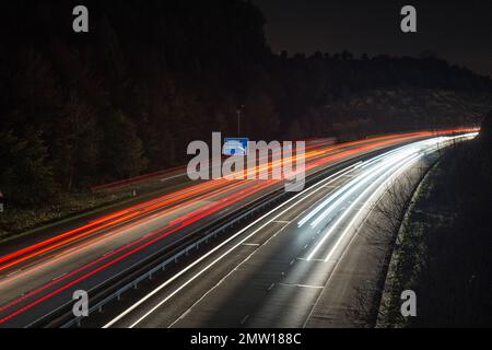 Light trails left by speeding traffic travelling through the night on the M40 motorway in the UK. Slow shutter speed and long exposure photography. Stock Photo