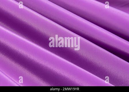 The texture of a luxurious smooth fabric in blue, purple with folds and waves. Blue fabric, material Stock Photo