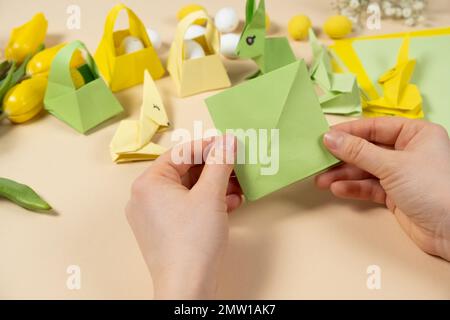 Handicrafts from paper for Easter - origami, making figurines of Easter bunnies, hands close-up Stock Photo
